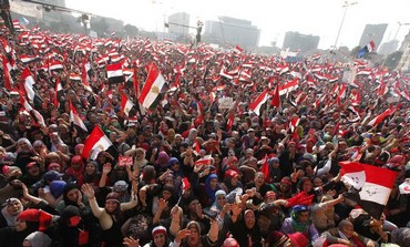 Protesters against Egyptian President Mohamed Morsi wave national flags