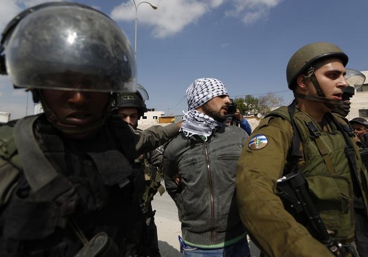 Israeli security forces detain a Palestinian near the West Bank town of Abu Dis