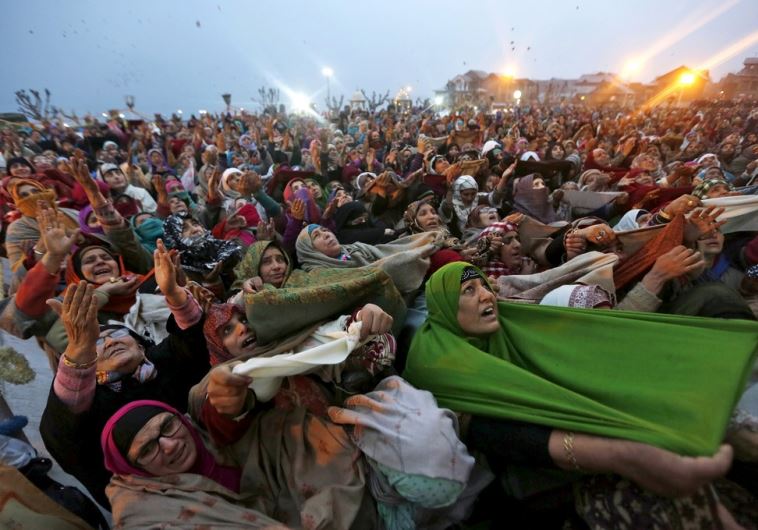 Kashmiri Muslim women raise their arms as they pray upon seeing a relic of Prophet Mohammad 