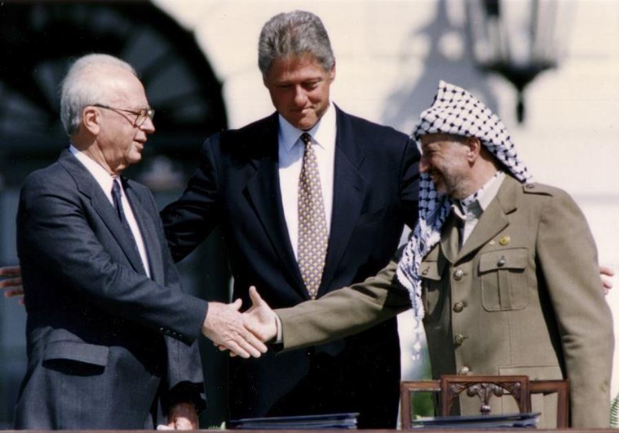 Then-PLO Chairman Yasser Arafat (R) shakes hands with then-prime minister Yitzhak Rabin (L)