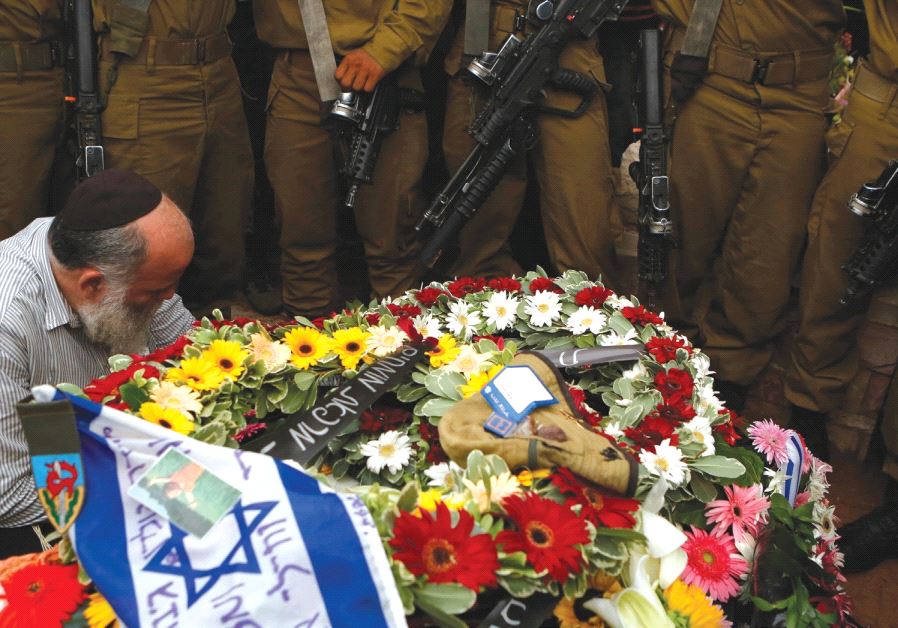 SOLDIERS STAND next to the grave of their comrade Lieutenant Hadar Goldin during his funeral in Kfar Saba in August 2014 (Reuters)