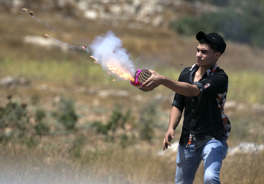 Palestinian uses flare during protest (AFP)