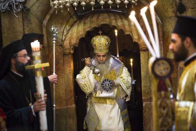 Greek Orthodox Patriarch of Jerusalem Metropolitan Theophilos (C) takes part in the Easter Sunday mass procession inside the Church of the Holy Sepulchre in Jerusalem's old city (photo credit: REUTERS)