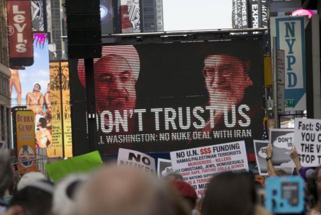 An image of Iranian leaders is projected on a giant screen in front of demonstrators during a rally opposing the nuclear deal with Iran in Times Square, July 22, 2015 (photo credit: REUTERS)