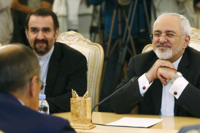 Iranian FM Mohammad Javad Zarif (right) listens to his Russian counterpart Sergei Lavrov (back facing) during their meeting in Moscow, Russia, (photo credit: MAXIM ZMEYEV/REUTERS)