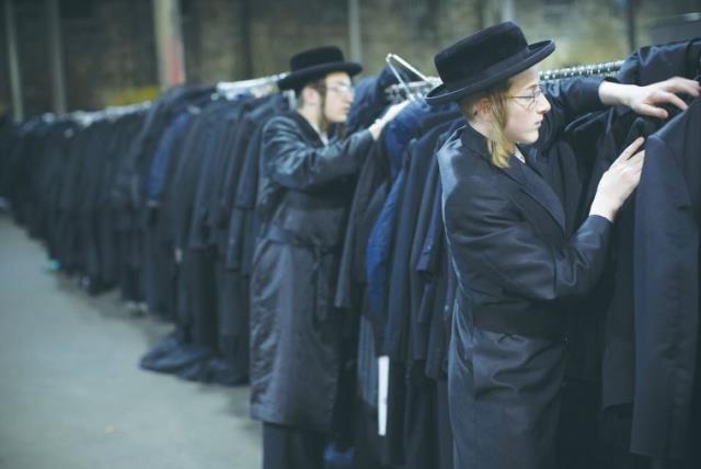 MEN SEARCH the cloak room for their jackets at a mass gathering of Satmar Hassidim in New York (photo credit: REUTERS)