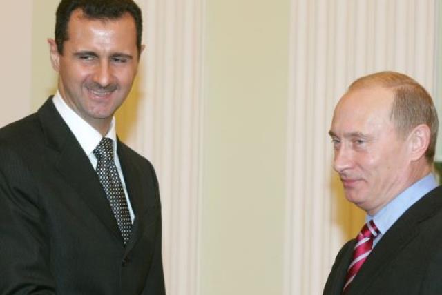 Russia's President Vladimir Putin (R) and Syrian President Bashar Assad shake hands as they meet in the Kremlin (photo credit: REUTERS)