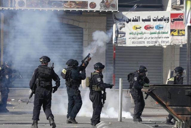 BORDER POLICEMEN fire tear gas at rock-throwers in the Shuafat refugee camp in northeastern Jerusalem on Friday (photo credit: REUTERS)