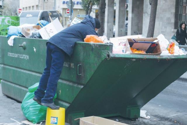 A man in Jerusalem searching through the garbage (photo credit: MARC ISRAEL SELLEM/THE JERUSALEM POST)