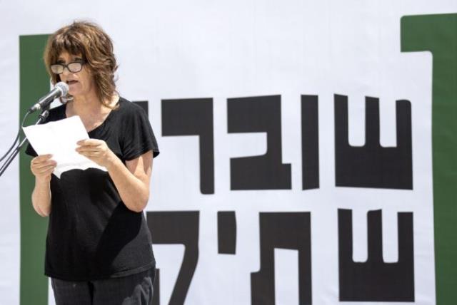 A woman reads testimonies during a gathering in Tel Aviv to commemorate the 10th anniversary of the Israeli NGO "Breaking the Silence" (photo credit: AFP PHOTO)