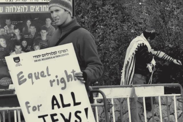 Protester holds a poster demanding equal rights for all Jews (photo credit: REUTERS)