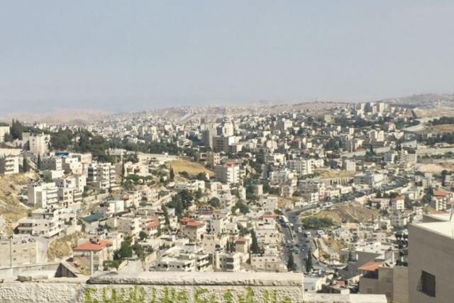 A VIEW from a-Tur of Arab neighborhoods in east Jerusalem, with Abu Dis, beyond the security barrier, in the distance. (photo credit: SETH J. FRANTZMAN)