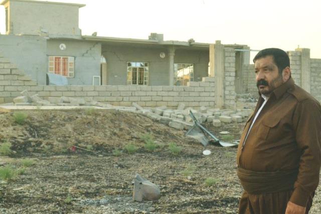 A KAKAI PESHMERGA volunteer stands next to a house destroyed by Islamic State. His brother was killed clearing explosives hidden by ISIS. ( (photo credit: LAURA KELLY)