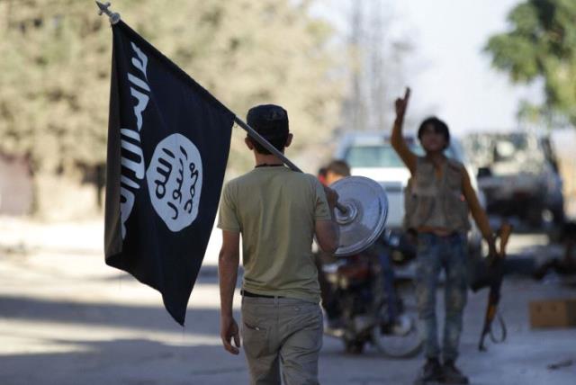 A rebel fighter takes away a flag that belonged to Islamic State militants in Akhtarin village, after rebel fighters advanced in the area, in northern Aleppo Governorate, Syria, October 7, 2016 (photo credit: REUTERS)