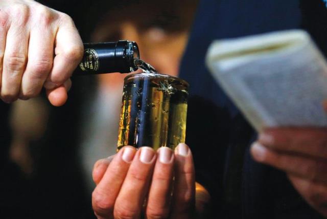 A CELEBRATORY GLASS OF WINE is poured before traditional blessings during an Orthodox wedding ceremony in Budapest, Hungary, in 2014. (photo credit: REUTERS)