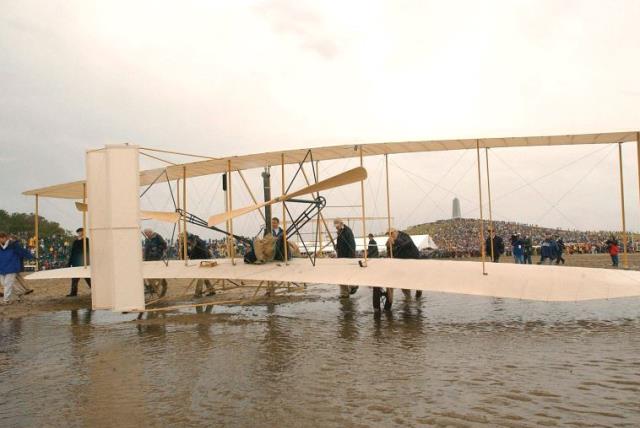 THE WRIGHT EXPERIENCE team rolls a Wright 1903 Flyer replica onto the field at the Wright Brothers National Memorial in Kill Devil Hills, North Carolina. (photo credit: REUTERS)