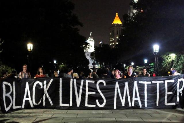 People hold up a banner during a Black Lives Matter protest outside City Hall in Manhattan, New York (photo credit: REUTERS)
