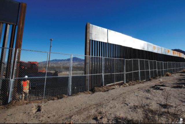 A WORKER STANDS next to a newly built section of the US border fence at Sunland Park, New Mexico, opposite the Mexican border city of Ciudad Juarez, on Wednesday. Picture taken from the Mexico side of the border. (photo credit: JOSE LUIS GONZALEZ/REUTERS)