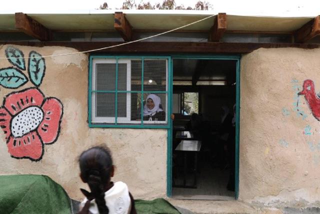 A BEDUIN SCHOOLGIRL looks out the window of her classroom at the Al-Khan al-Ahmar school, near the West Bank city of Jericho. (photo credit: REUTERS)