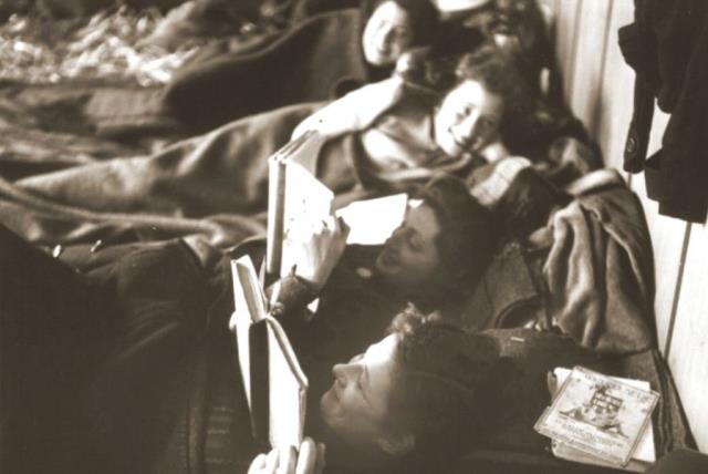 Jewish women rescued from Theresienstadt read while resting on their beds in the Hadwigschulhaus in St. Gallen, Switzerland (photo credit: WALTER SCHEIWILLER/UNITED STATES HOLOCAUST MEMORIAL MUSEUM)