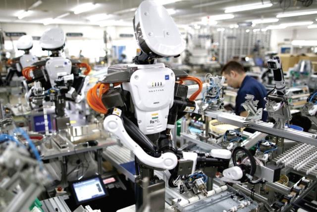 Humanoid robots work side by side with employees in the assembly line at a factory near Tokyo, Japan (photo credit: REUTERS)