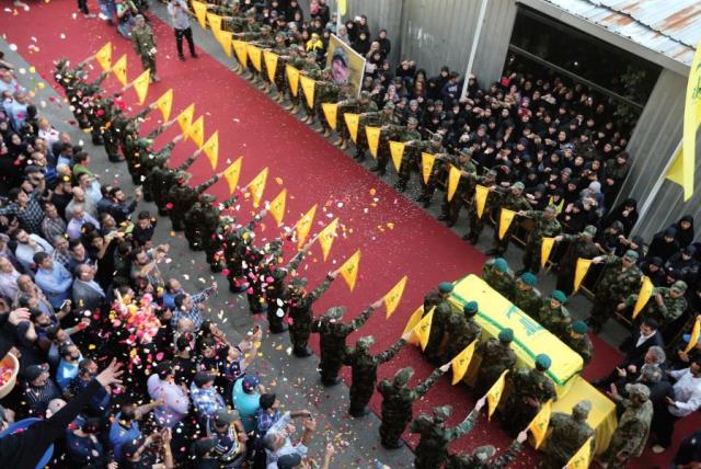 PEOPLE TOSS rose petals as Hezbollah members stand near the coffin of top Hezbollah commander Mustafa Badreddine, who was killed in an attack in Syria last year (photo credit: REUTERS)