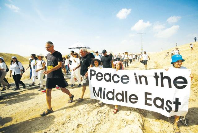 Demonstrators including Israeli and Palestinian activists take part in a demonstration in support of peace near Jericho last year (photo credit: REUTERS)