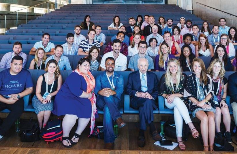 REALITY GLOBAL participants pose for a photograph with former president Shimon Peres ahead of his address to them at the Peres Peace Center in Tel Aviv yesterday (photo credit: NETANEL TOBIAS)