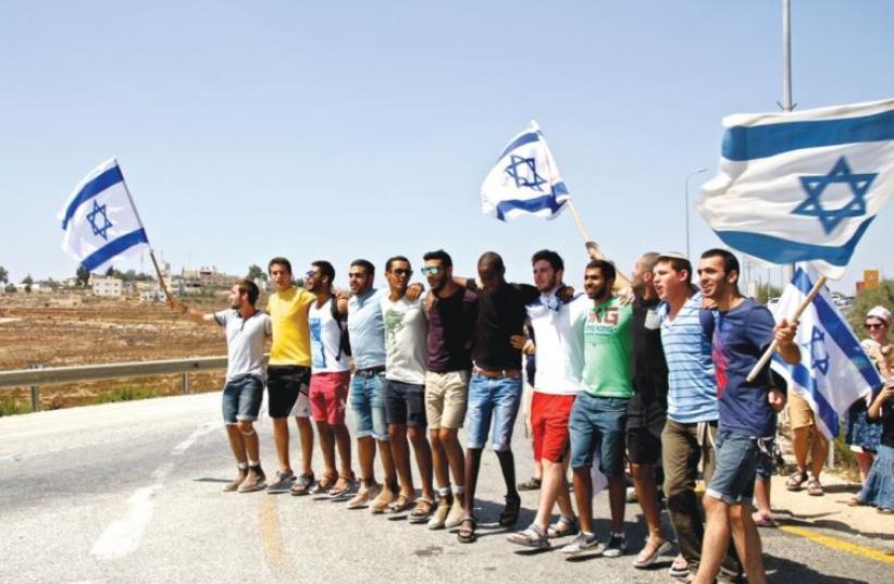 Right-wing Israeli demonstrators (bottom) express support for the IDF outside Halamish (photo credit: TOVAH LAZAROFF)