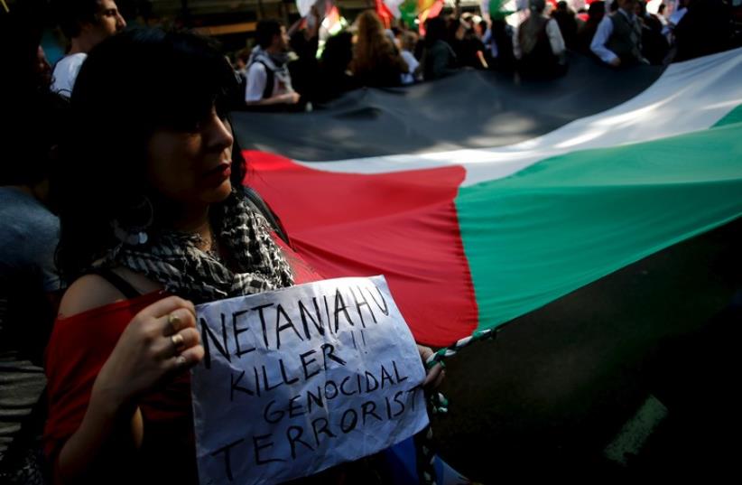 A protester holds a sign against Prime Minister Benjamin Netanyahu during a pro-Palestinian demonstration outside the Israeli Embassy in Buenos Aires, October 30, 2015 (photo credit: REUTERS)