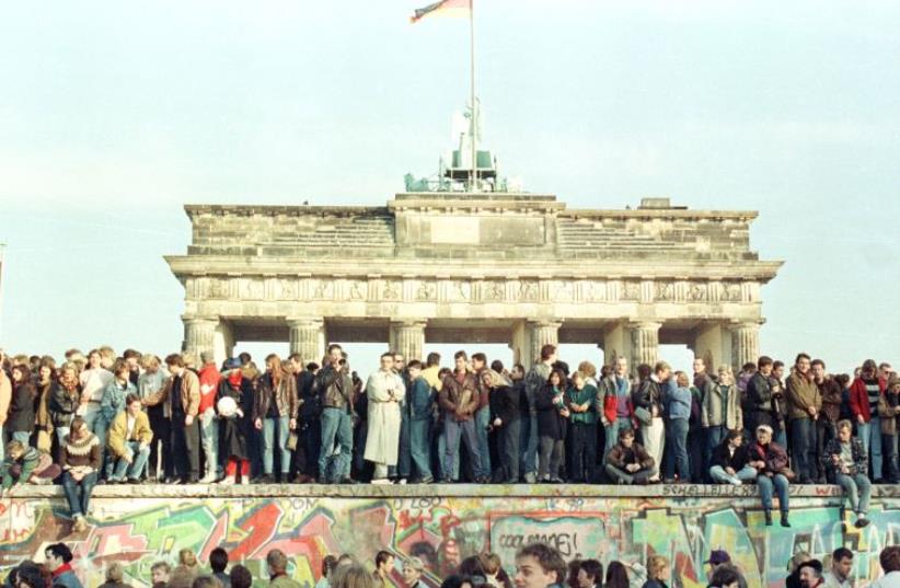 West Berlin citizens continue their vigil atop the Berlin Wall in front of the Brandeburg Gate in this November 10, 1989 file photo (photo credit: REUTERS)