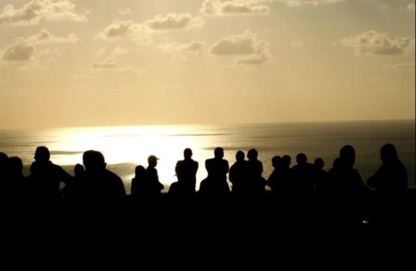 Lebanese soldiers stand at sunset inspecting the site where a suspicious device was found by a military intelligence patrol and reportedly blown up by Israel (photo credit: AFP PHOTO)