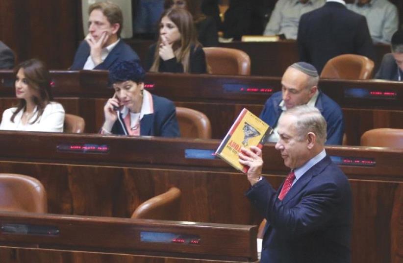 Benjamin Netanyahu reading a book during budget votes (photo credit: MARC ISRAEL SELLEM/THE JERUSALEM POST)