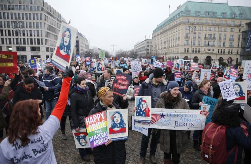 People gather in front of the US Embassy on Pariser Platz beside Brandenburg Gate in solidarity with women's march in Washington and many other marches in several countries, in Berlin, Germany, January 21, 2017.  (photo credit: REUTERS)