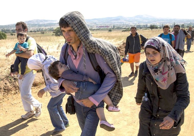 Syrian refugees walk along a road in Serbia, August 24, in an increasingly desperate journey to western Europe (credit: MARKO DJURICA / REUTERS)