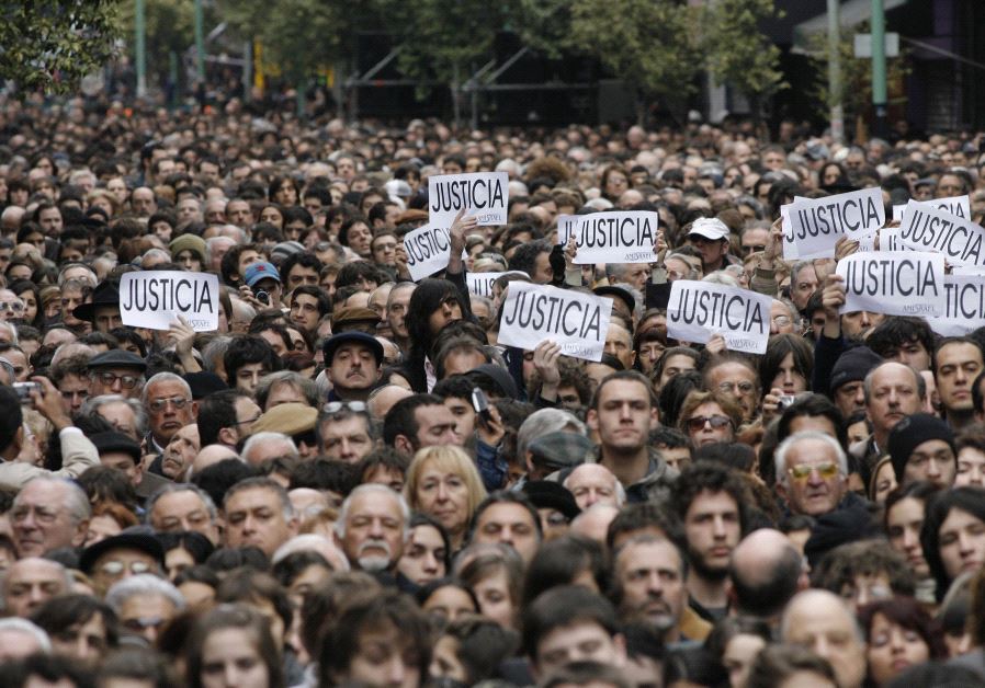 Hundreds of people, most of them members of the Argentine Jewish community, attend the commemoration of the 13th anniversary of the 1994 bombing of the AMIA Jewish community center in Buenos Aires July 18, 2007. The signs read, ''Justice. (credit: REUTERS)